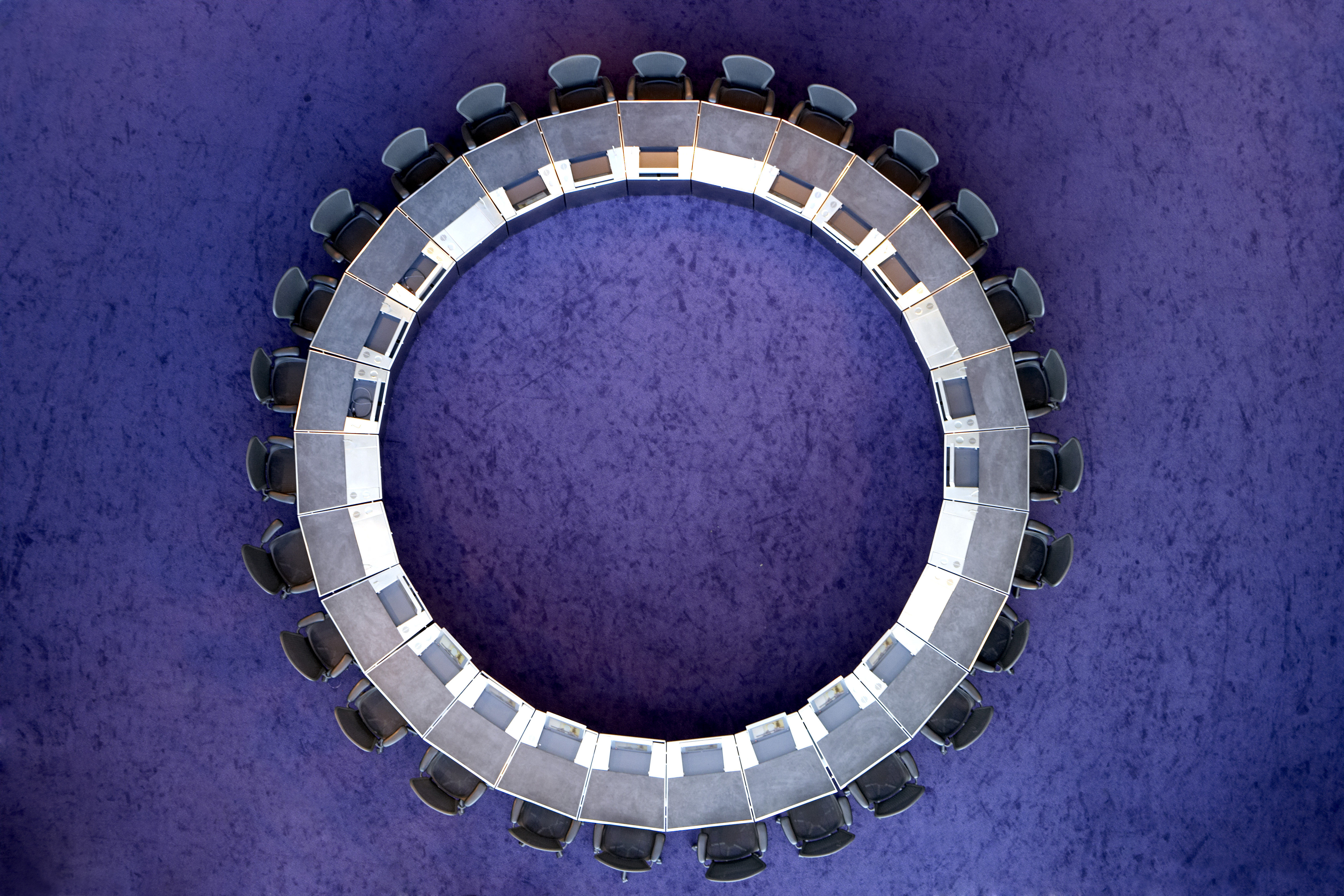 Aerial view of circular table with surrounding chairs and purple floor