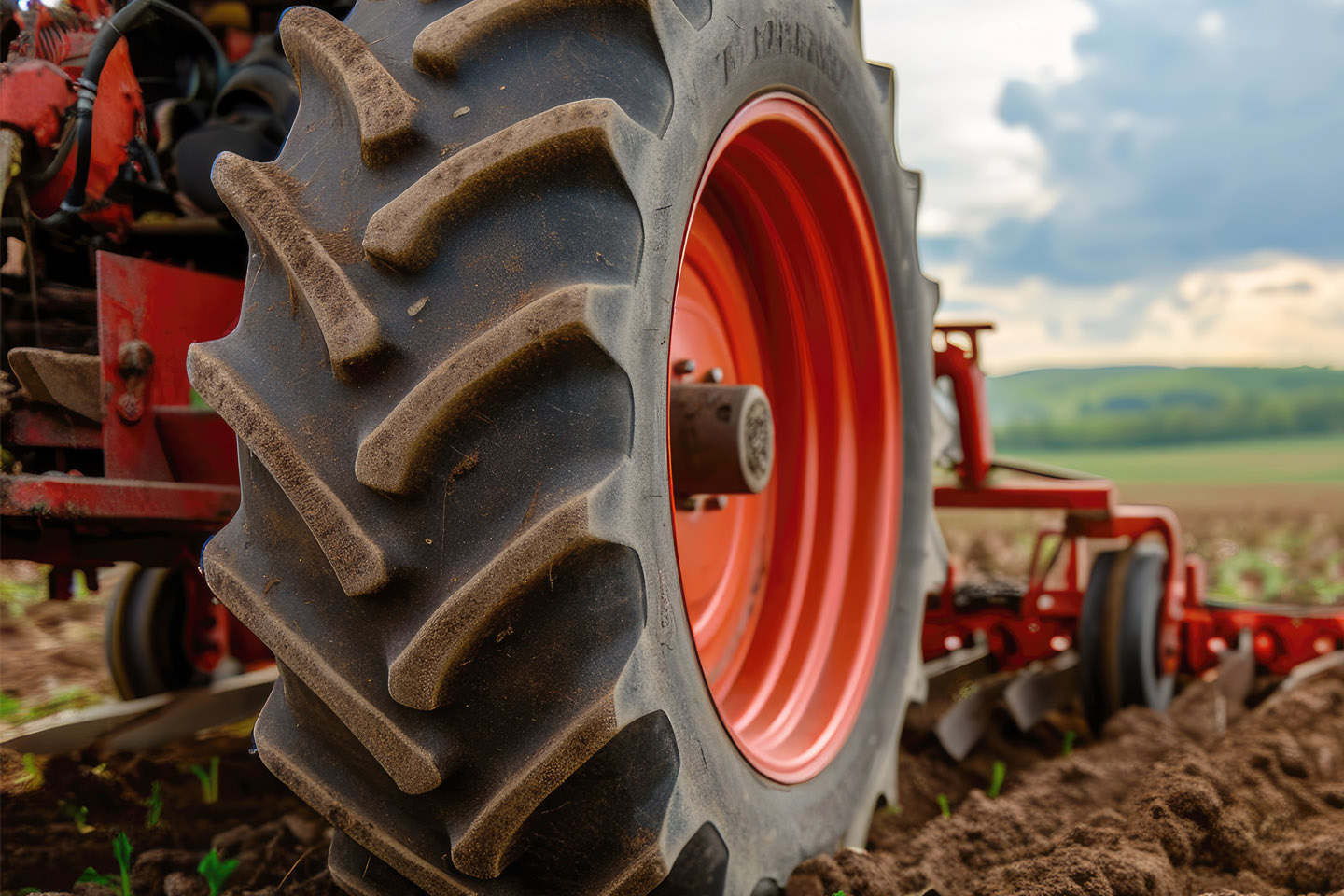 close up of a red tractor's wheel whilst ploughing field